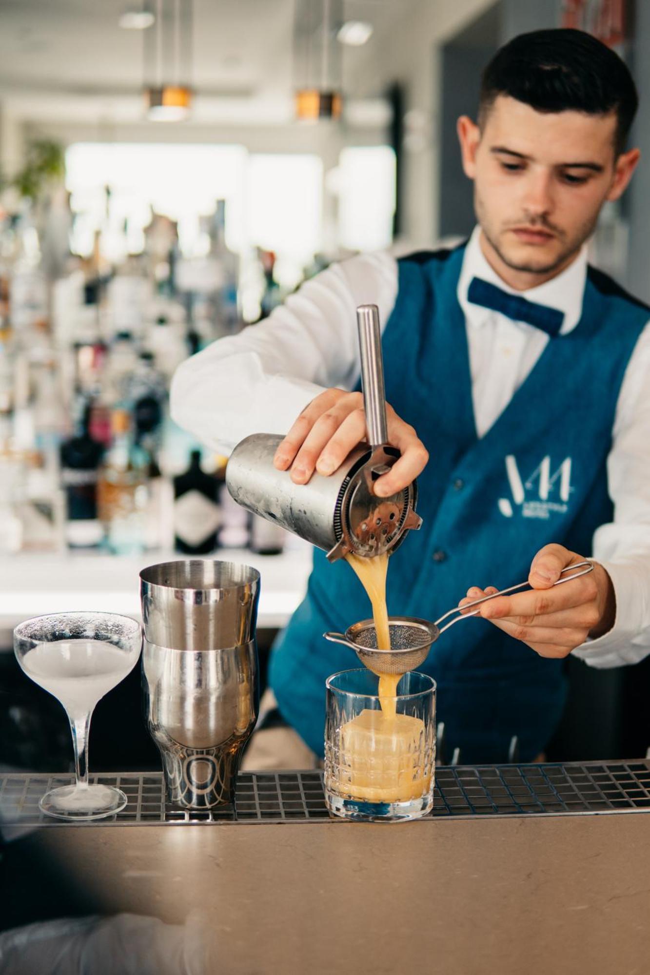 J44 Lifestyle Hotel Lido di Jesolo Luaran gambar A bartender straining a cocktail